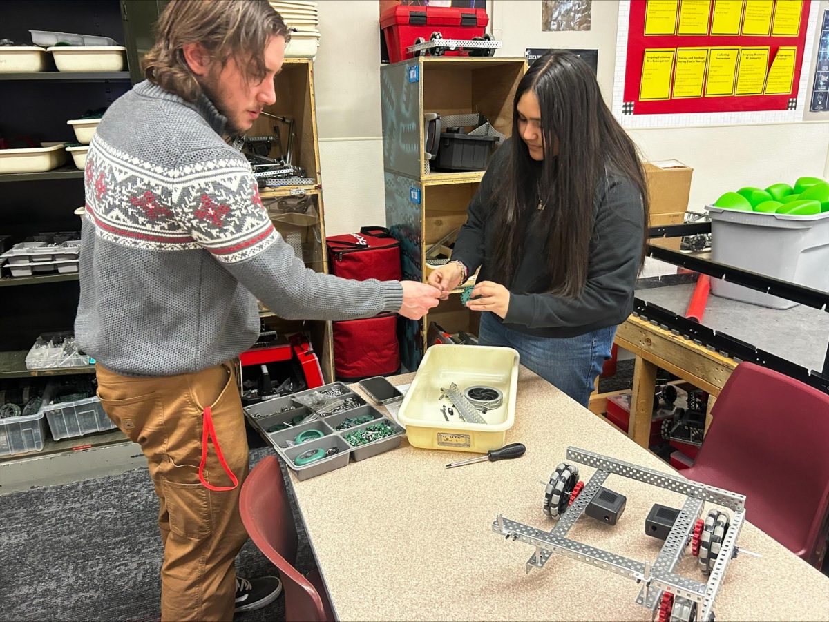 Leo Fogel helps Denise Hernandez with her robot during robotics club.