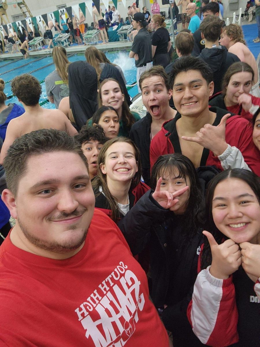 Coach Charles Miles and members of Souths swim team celebrate their victories.