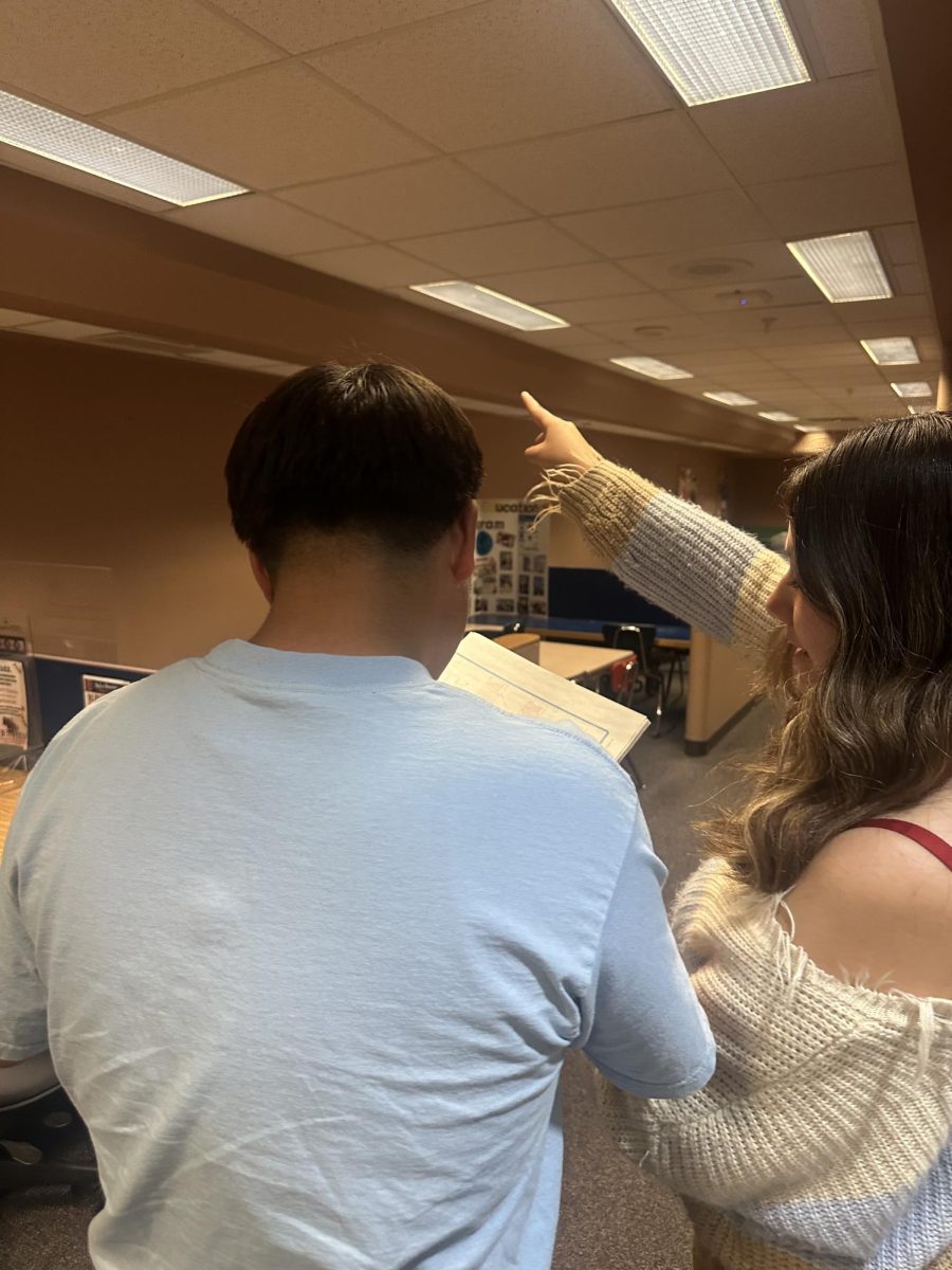 Teachers notice growth and maturity in students between freshman and senior years. A senior, above, helps an underclassman with his schedule.